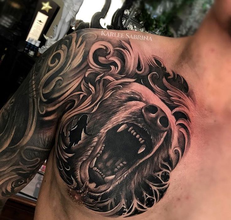 a man's chest with a bear tattoo on it