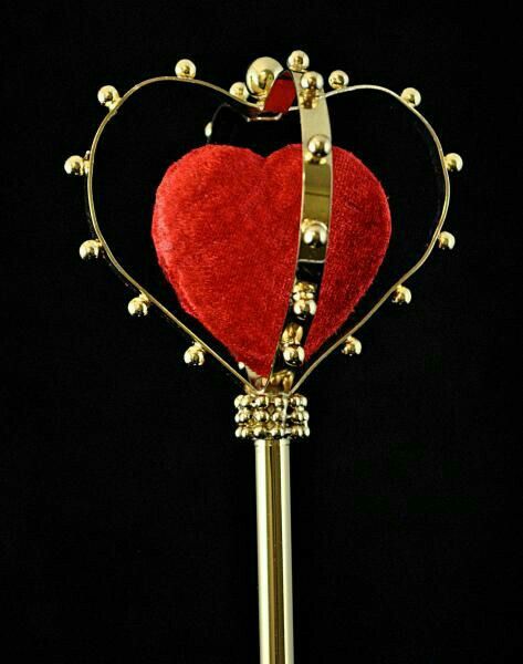 a golden key with a red heart on it's end and a black background