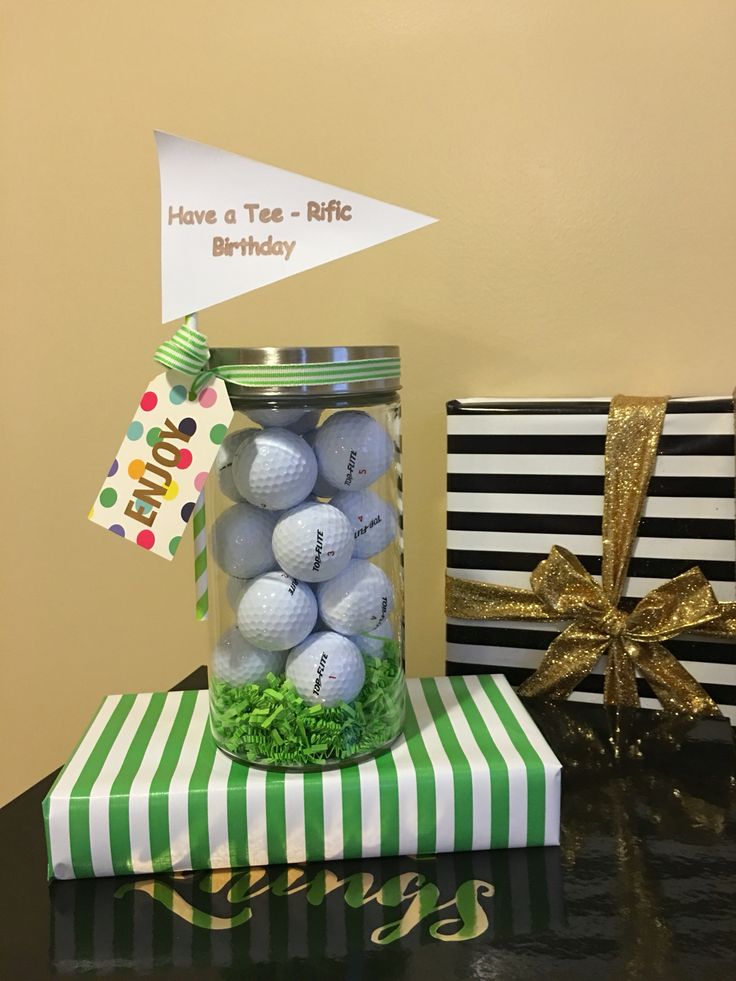 a jar filled with golf balls sitting on top of a green and white striped box