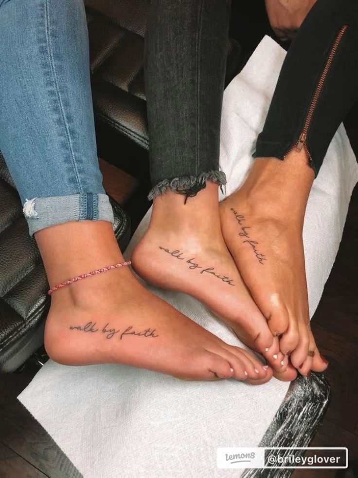 two people with matching feet sitting on a chair and one has writing on their toes