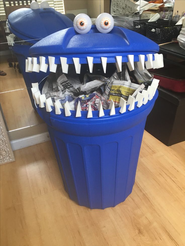 a blue trash can with fake teeth and eyes