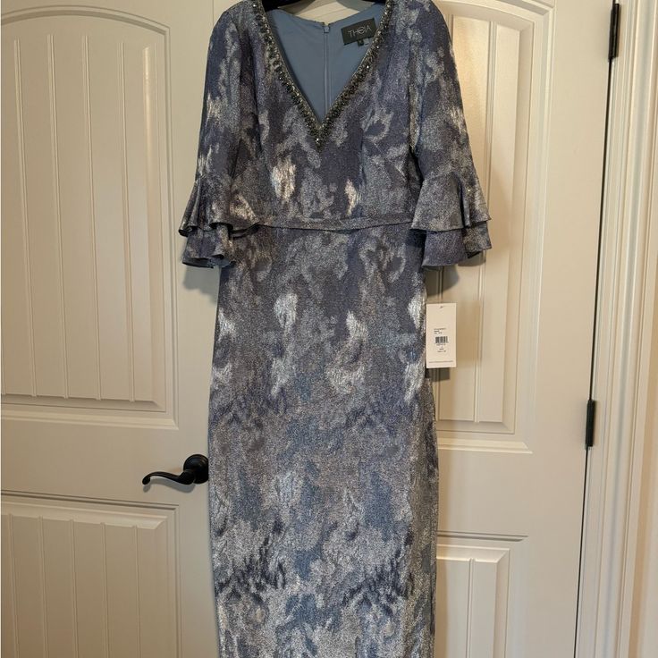 a dress hanging on a hanger in front of a door