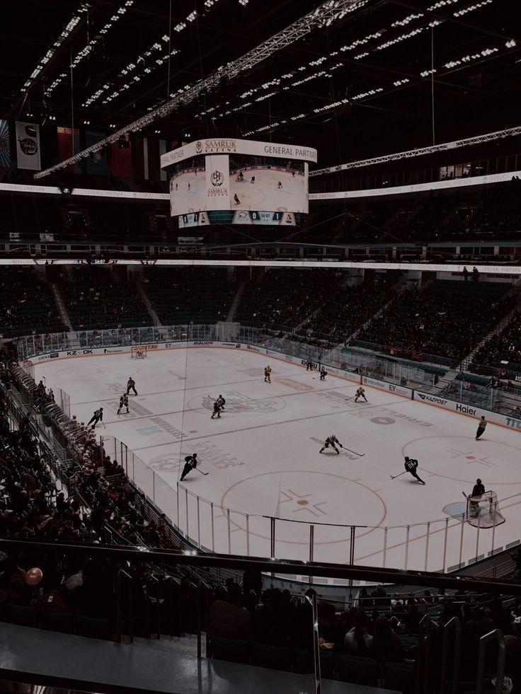 an ice hockey game is being played in a large arena