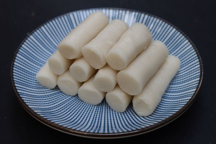 several pieces of food on a blue and white plate with black table cloth in the background