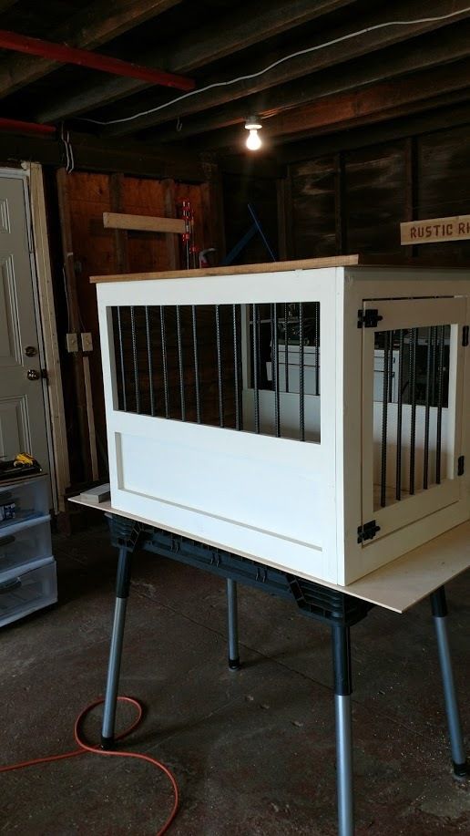 a white dog crate sitting on top of metal legs