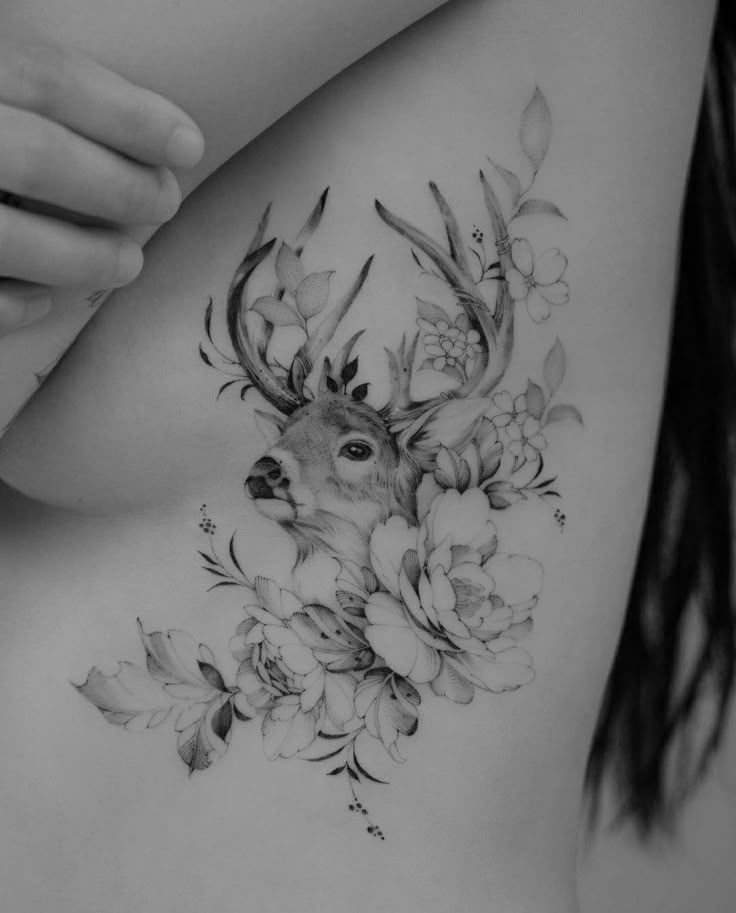 a woman's back with flowers and deer head on it