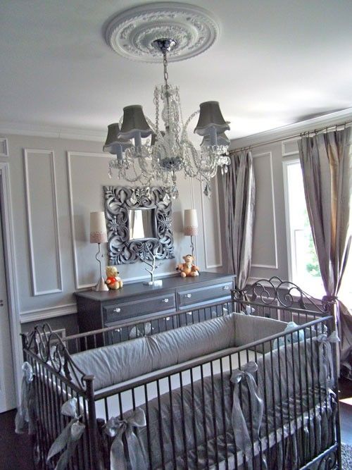 a baby crib with a chandelier hanging from the ceiling