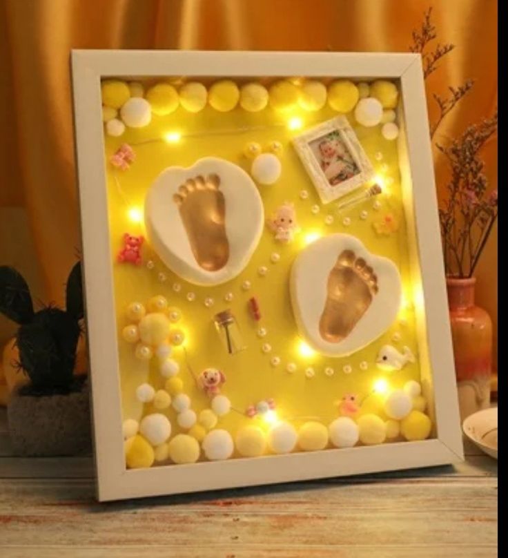 a baby's hand and foot casts are displayed in a shadow box with lights