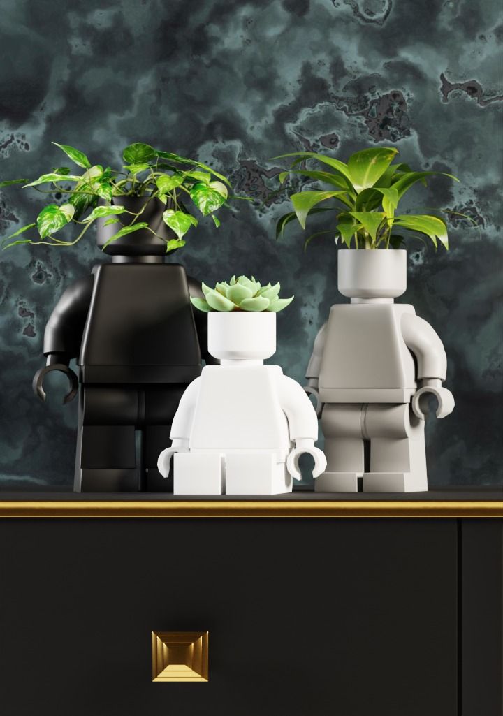 two legos are sitting next to each other with plants in their pots on top of them