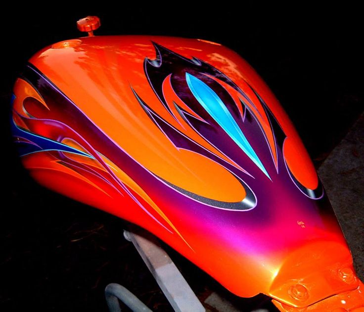 an orange and purple motorcycle with flames painted on it