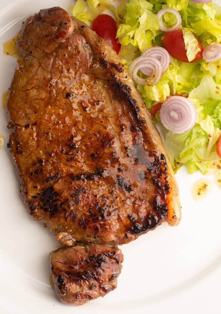 a white plate topped with meat and salad