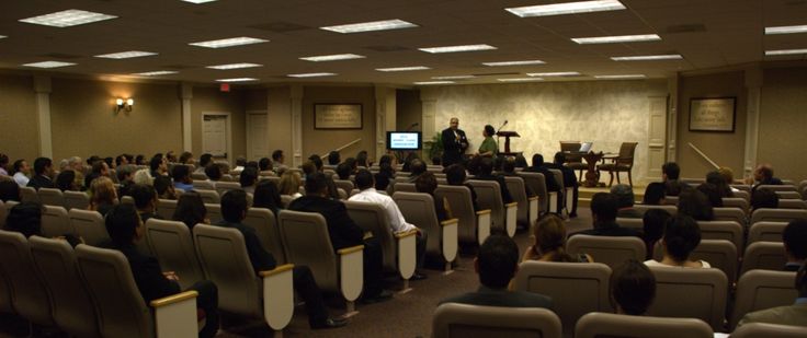 an auditorium full of people sitting in chairs