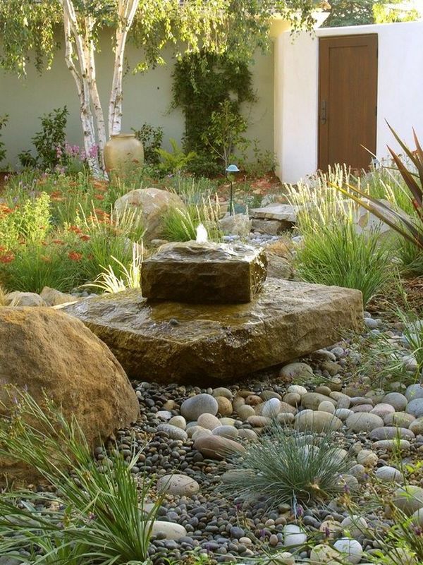 a garden with rocks and plants around it