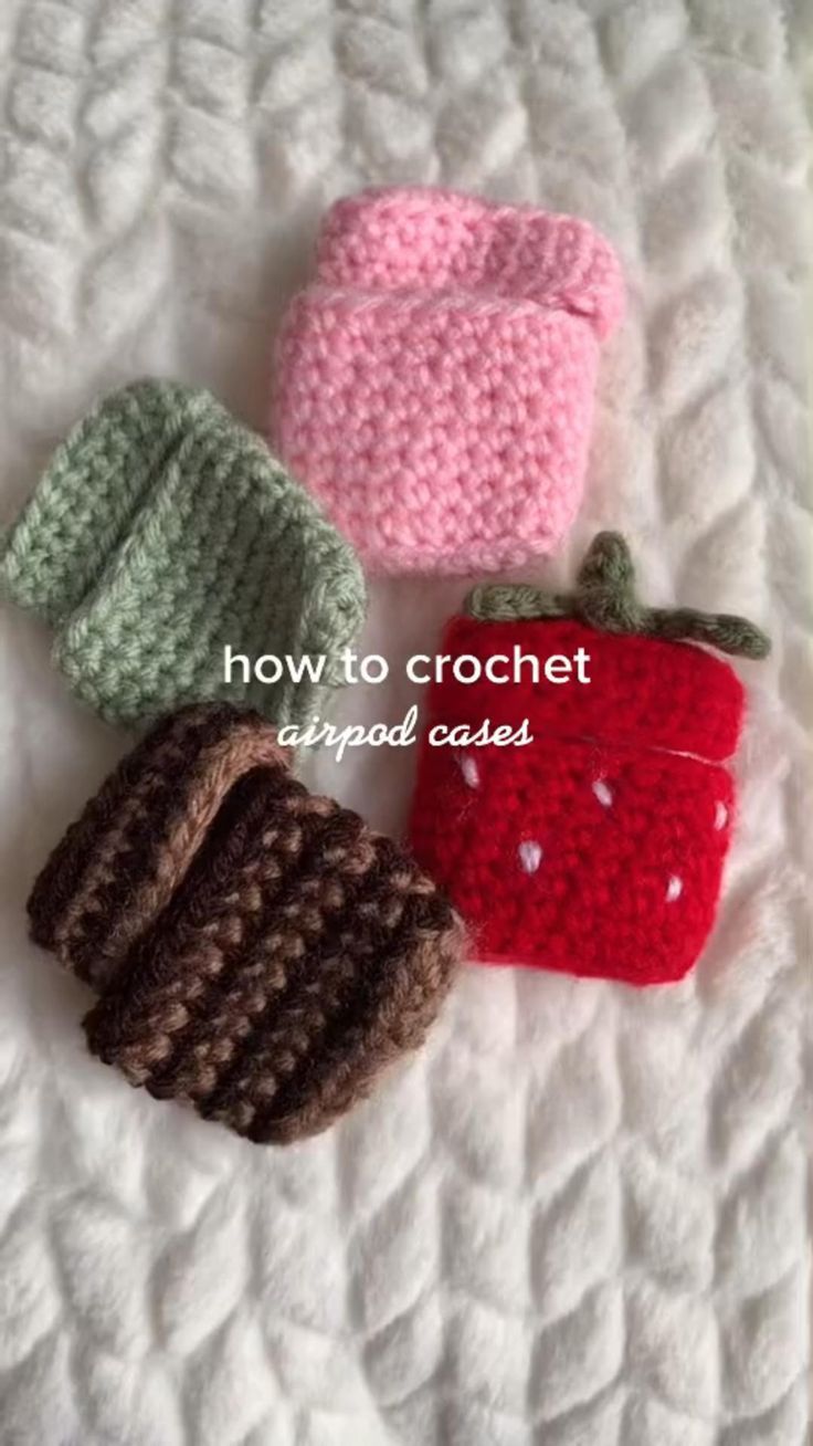 four crocheted purses sitting on top of a white bed next to each other