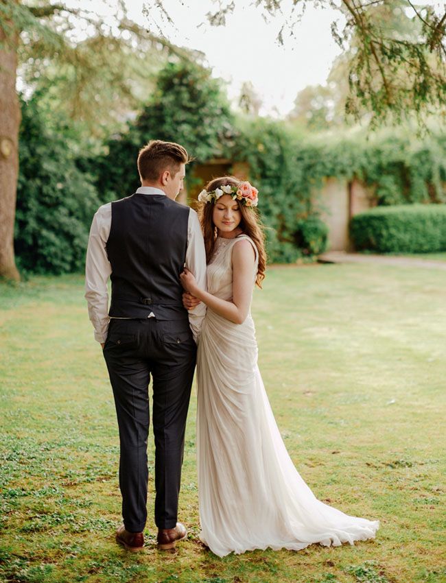 a bride and groom standing in the grass