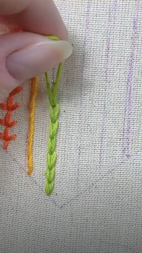 someone is stitching something on the side of a piece of fabric with two different colored threads