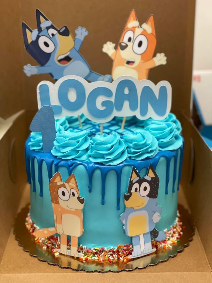 a birthday cake with blue frosting and cartoon characters on it that says logan