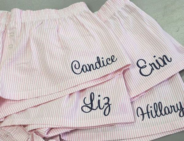 three pink and white striped shorts with embroidered words on the front, bottom and bottom