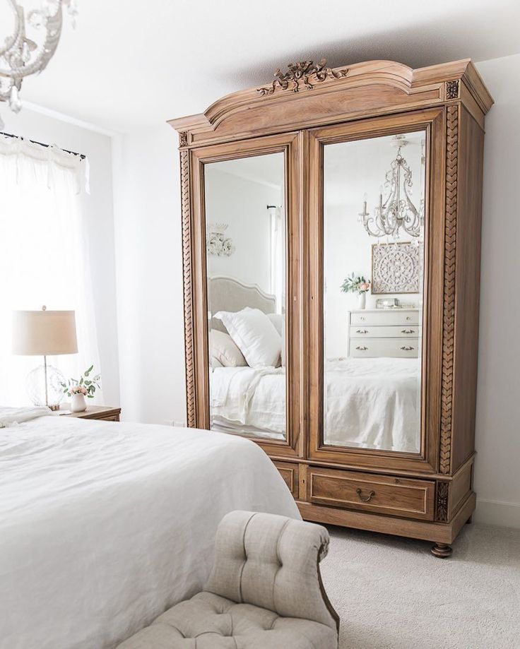 a bedroom with a bed, dresser and mirror