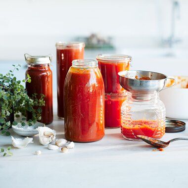 jars filled with different types of sauces on a table