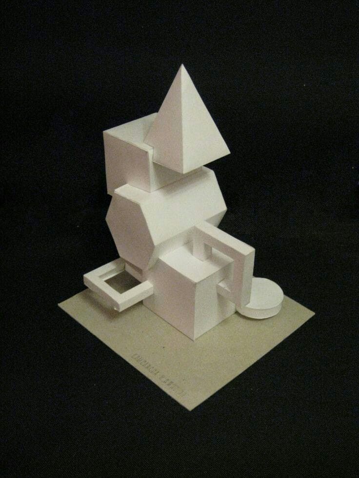 a white sculpture sitting on top of a piece of paper