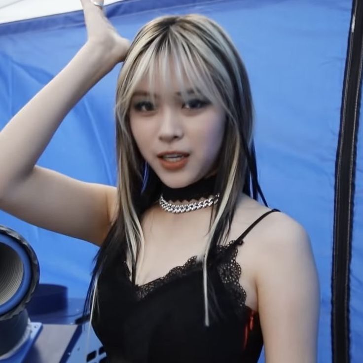 a young woman posing in front of a speaker