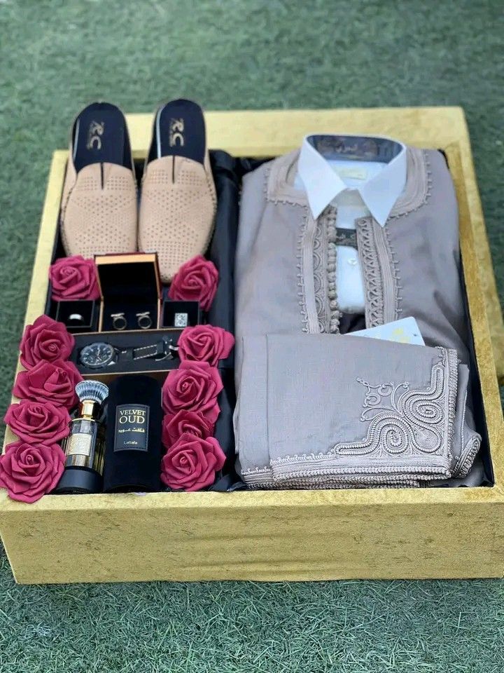 an open box containing men's clothing, shoes and other items on the ground