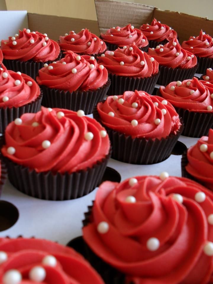 cupcakes with red frosting and white decorations