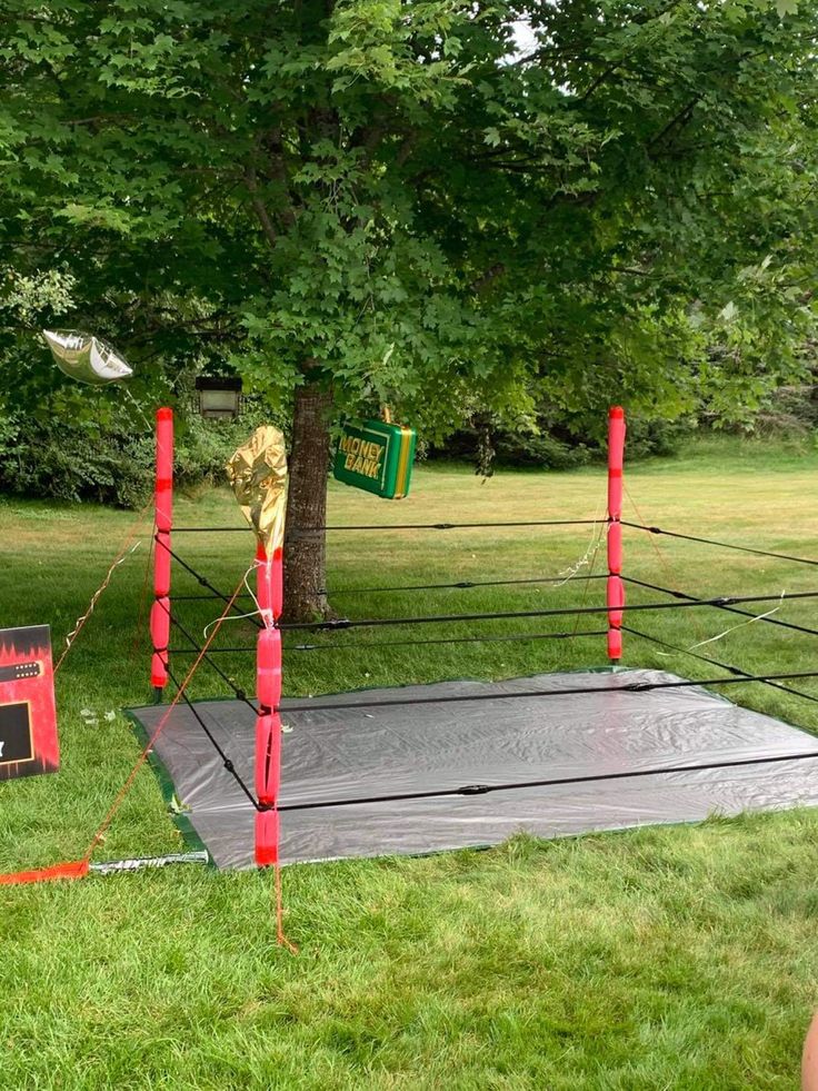 a man standing next to a boxing ring in the grass