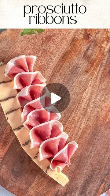 prosciutto ribbons on a cutting board with cheese and meat in the middle