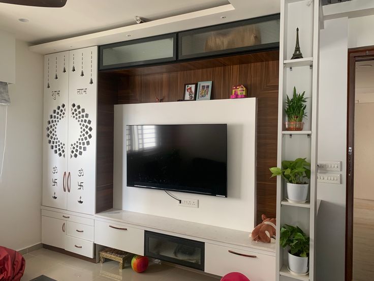 a flat screen tv sitting on top of a white entertainment center in a living room