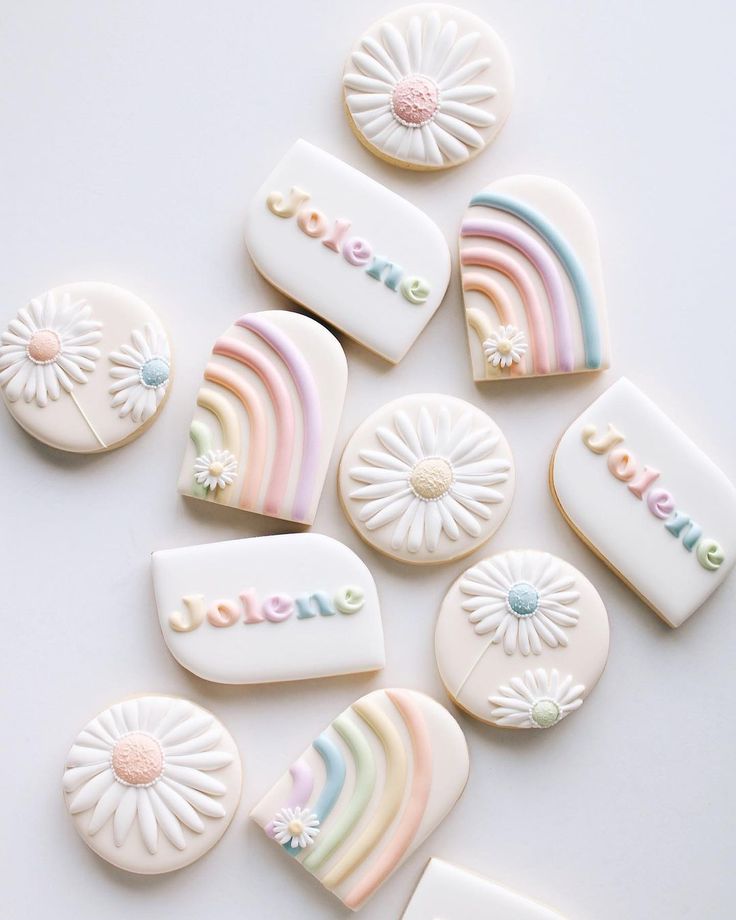 some cookies that are shaped like rainbows and sunflowers with the word love spelled on them