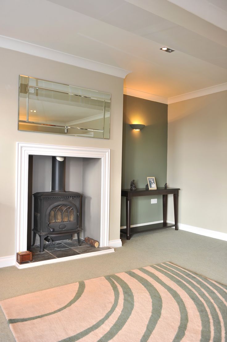 a living room with a fire place in the corner and a rug on the floor