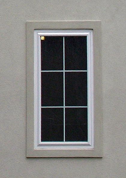 a bird sitting on the ledge of a window