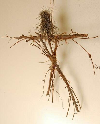 a bunch of twigs that are hanging from the ceiling in front of a white wall