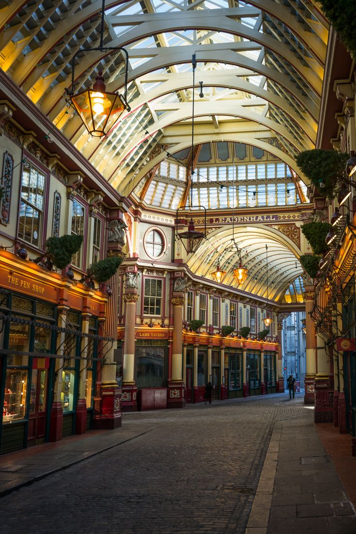 the inside of an old shopping mall with many windows and shops on both sides,