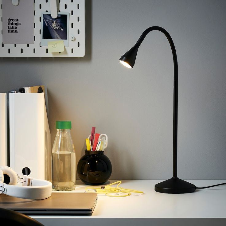 a desk lamp sitting on top of a table next to a book and other office supplies