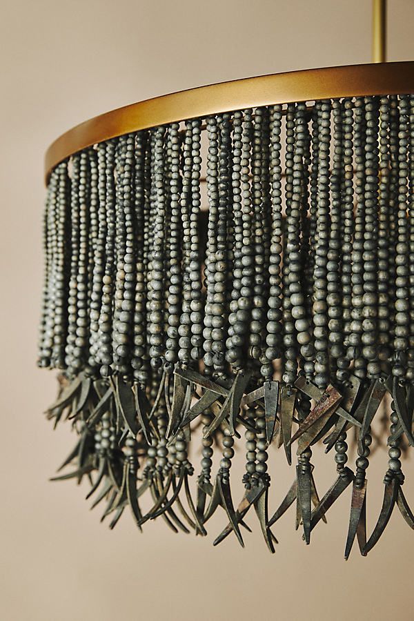 a chandelier hanging from a ceiling with beads and metal blades attached to it