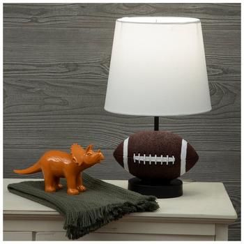 a lamp that is sitting on top of a table next to a stuffed animal and football