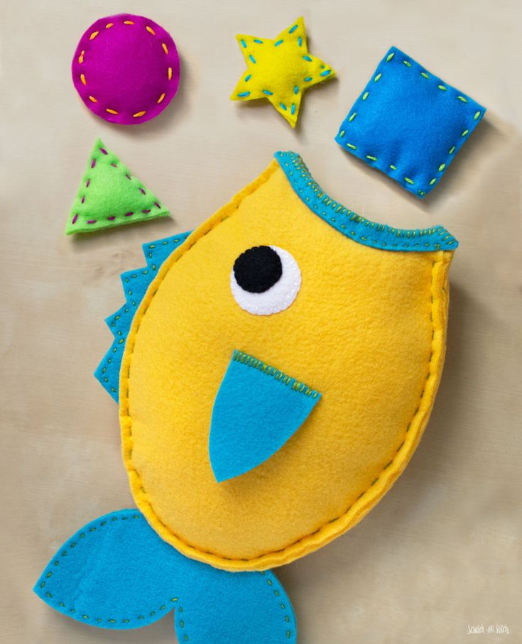 a close up of a stuffed animal on a table with other felt items in the background