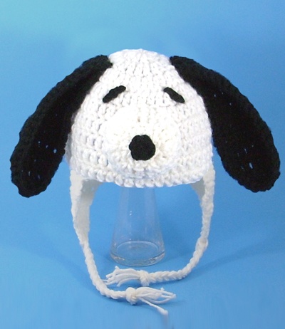 a crocheted hat with a black and white dog's face on it