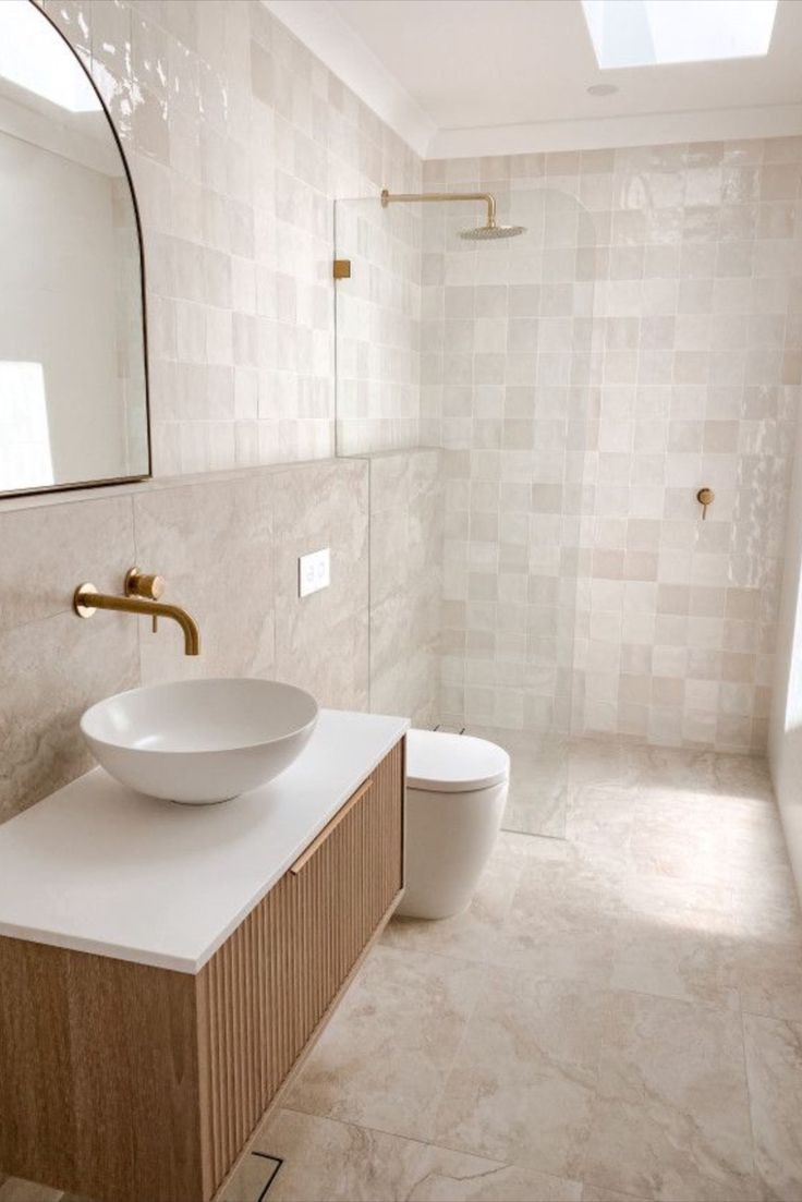 a bathroom with a sink, mirror and toilet in it's center area is shown