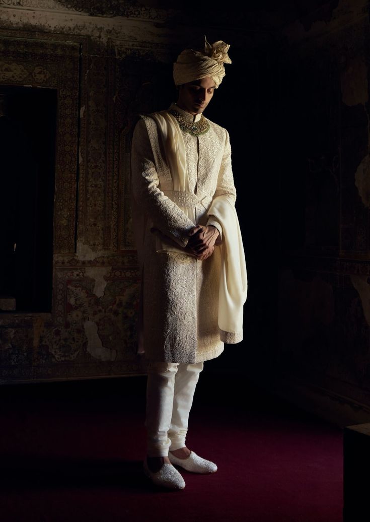 Achieve timeless sophistication in this ivory raw silk sherwani, featuring tonal dori work and highlighted with beads, pearls, and crystals. Accompanied by a cotton silk kurta and churidar, it comes with a worked stole and belt. Reception Sherwani With Chikankari Embroidery In Raw Silk, Sherwani With Chikankari Embroidery In Raw Silk For Reception, Traditional Chikankari Embroidered Raw Silk Bandhgala, Chikankari Embroidered Raw Silk Bandhgala, Traditional Wear In Raw Silk With Pearl Embroidery, Raw Silk Bandhgala With Cutdana For Reception, Traditional Raw Silk Wear With Pearl Embroidery, Traditional Pearl Embroidered Raw Silk Wear, Elegant Cream Churidar With Cutdana Detailing