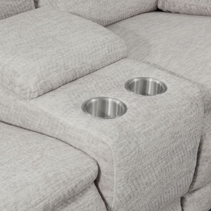 two metal bowls are placed on the back of a couch that's reclining