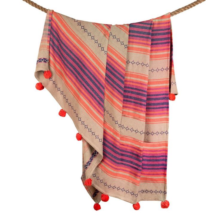 an orange, pink and purple striped blanket hanging on a rope with pom - poms