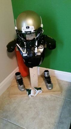 a helmet and skis sitting on top of a wooden stand in front of a green wall