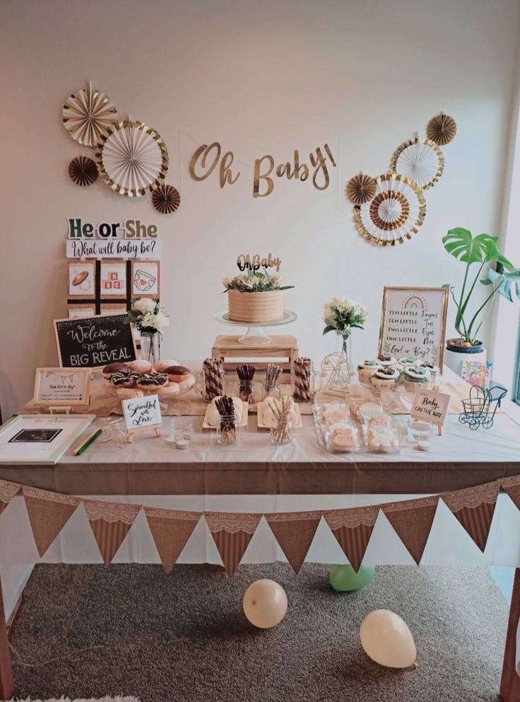 the dessert table is set up for a baby shower or bridal party with gold and white decorations