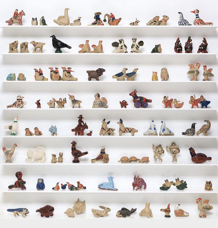 a white shelf filled with lots of different types of figurines