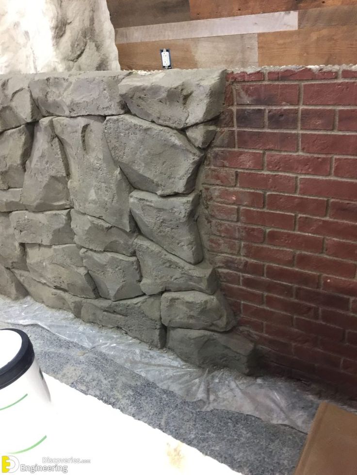 a wall made out of large rocks next to a brick wall in a room that is being remodeled