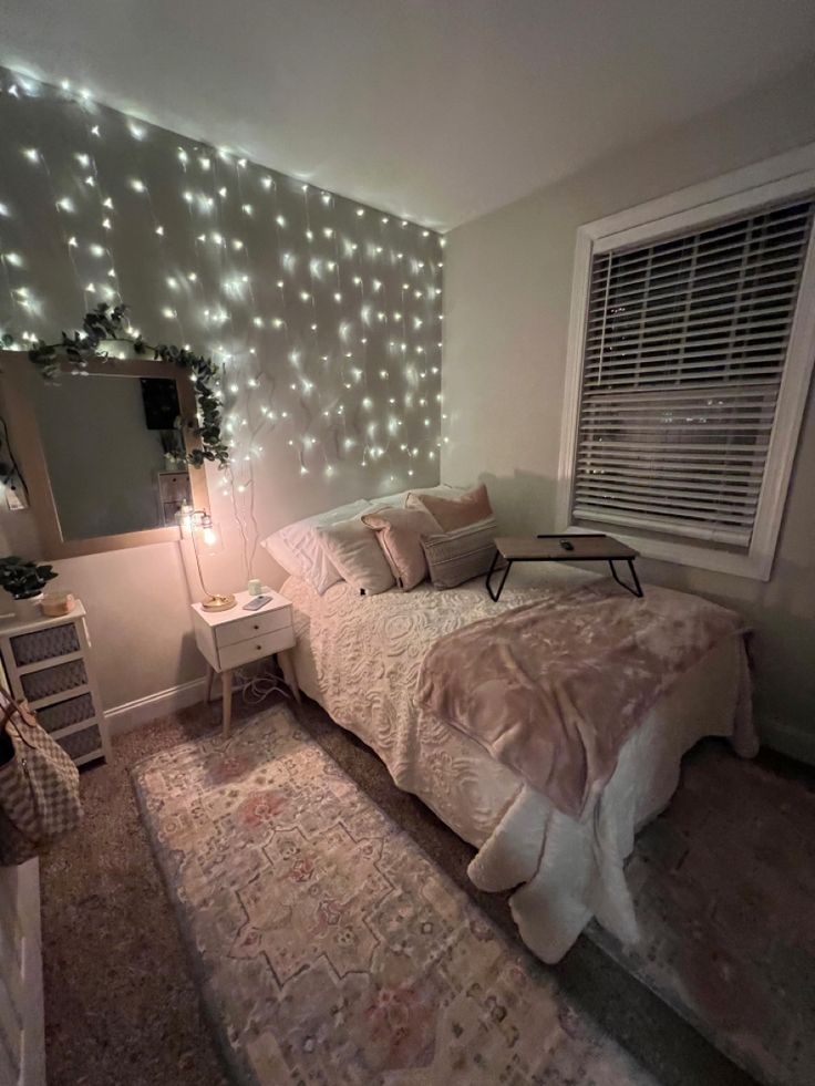 a bed room with a neatly made bed and lights on the wall